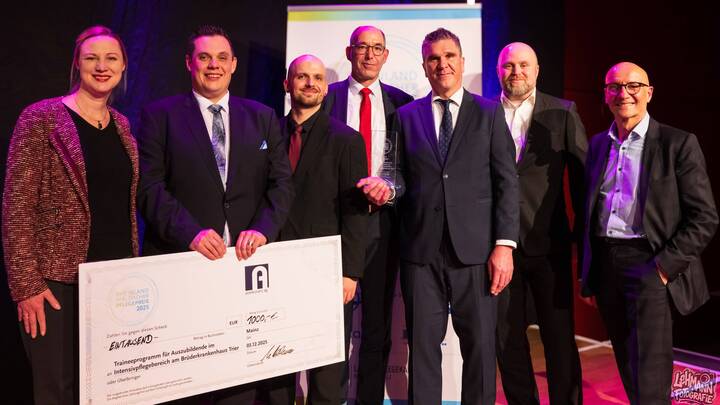 Freuen sich über die Auszeichnung (v. l.): Dörte Schall, Ministerin für Arbeit, Soziales, Transformation und Digitalisierung Rheinland-Pfalz, Thomas Spieles und Jonas Wilkesmann von der Intensivstation 1E des Brüderkrankenhauses Trier, Matthias Bellmann von der Assekuranz AG, Andreas Gödert, pflegerische Gesamtleitung Intensivstation 1E, David Mager, Stabsstelle Pflegedirektion, sowie Jörg Mogendorf, Pflegedirektor des Brüderkrankenhauses Trier.